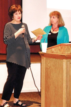 Mary Couzens (left) presents donations, received from PebbleCreek residents that attended a concert sponsored by Mary Couzens Realty, to the President of Kare Bears, Mary McMahon.