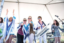 Traci Baker, PebbleCreek’s Director of Community Activities and Linda Robson, Editor of The PebbleCreek Post, perform onstage with AbbaFab.