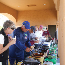 Members lined up tasting the 15 chili entries.