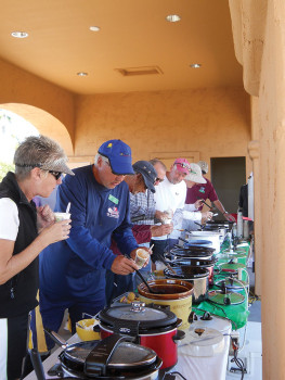 Members lined up tasting the 15 chili entries.