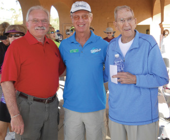 HOA President John Kiekbusch (left) and the pickleball club’s founder and first President Grover Lumbard (right) cut the ribbon to open the tournament. Current President Mike Crabtree (center) was master of ceremonies.