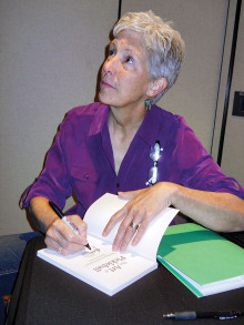 Gale Leach autographs her book on pickleball.