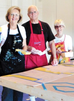 Artists Judy Hale, Duane Langston and Alla Langston paint the set pieces for A Night at the Renaissance.