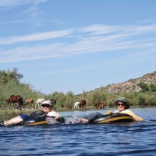 Wild Horses provide a picturesque background for this photo of PC Singles Club members Jackie Havranek and Rosemary Vana during one of the more peaceful moments of their recent tubing trip on the Salt River.