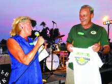 During the annual Dinner-Concert, club secretary Jules Cardinale unveils the new club logo created by John Meyers and presents him with the first shirt bearing the new logo; photo by Doreen Cooke.