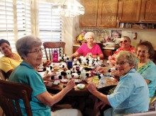 Ladies are making dogs from washcloths for shoe boxes.