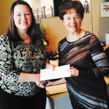 Melissa Gonzales (left) presents a gift certificate to Di Week.