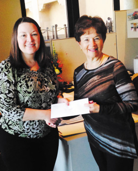 Melissa Gonzales (left) presents a gift certificate to Di Week.