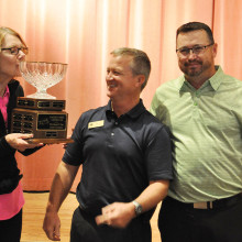 Jane Wiederhold is presented with the Developer’s Cup trophy by Golf Pros Dave Vader and Ronnie Decker.