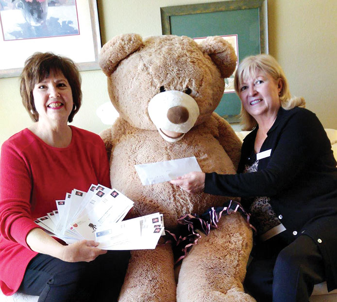 Mary Couzens (left) presents a contribution from Mary Couzens Realty Fun for Charity Concerts to the Kare Bears' Bear and Corrine Adams, a Kare Bear volunteer!