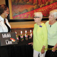 Wii bowling coach Bonita Sims shows prizes to event chairmen Elaine DeKruif and Dolores Rippe.