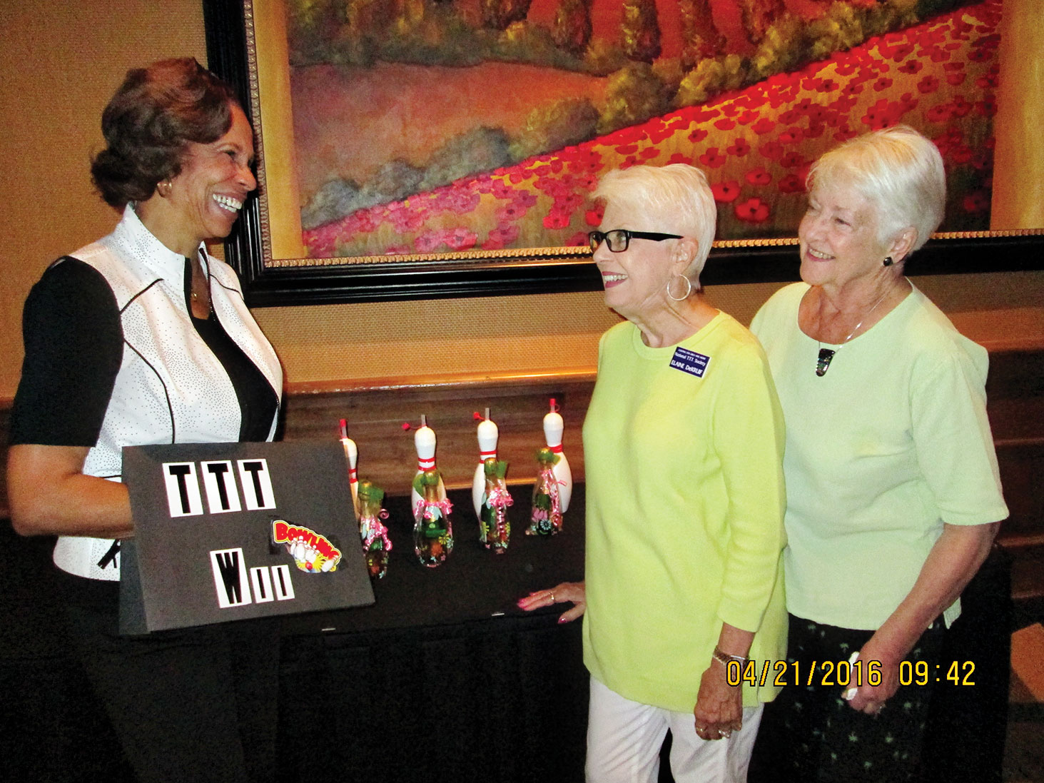 Wii bowling coach Bonita Sims shows prizes to event chairmen Elaine DeKruif and Dolores Rippe.