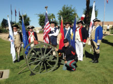 Arizona Sons of the American Revolution led in PebbleCreek by homeowner Matt Scott (first from left) gather around a cannon owned by PebbleCreek resident Todd Smith (front), after PebbleCreek’s commemoration of Armed Forces Day.