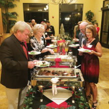 Holiday party guests at buffet table