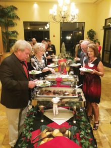 Holiday party guests at buffet table