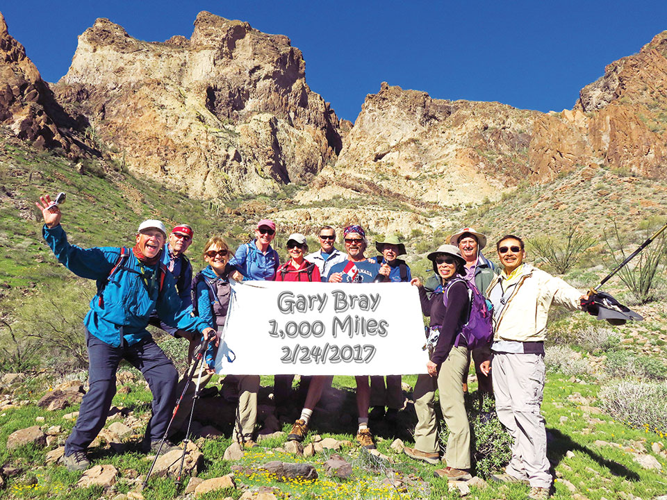 Left to right: Jeff Gillen, Lynn Warren (photographer), Donna Gillen, Julie Walmsley, Susan Bernt, Les Reister, Gary Bray, Len Jeffery, Beverly Kim, Steve Duncanson and Ed Kim pausing on an unusually green slope laced with poppies on the south side of Saddle Mountain.