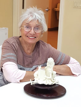 Sheila Millendorf with her sculpture Wonderland Story Teller.