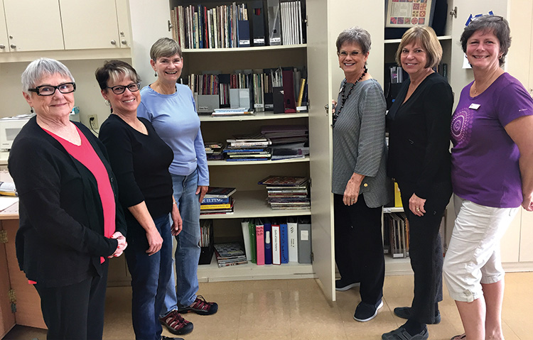 Linda Labenz (third from the right) with Sharon Pucelik, Mary Sabatello, Mary Hill, Lia McCromick and Karri Heywood-Smith. She is showing them the many printed resources available to all members which includes many books, magazines, informative material and patterns that may be checked out.