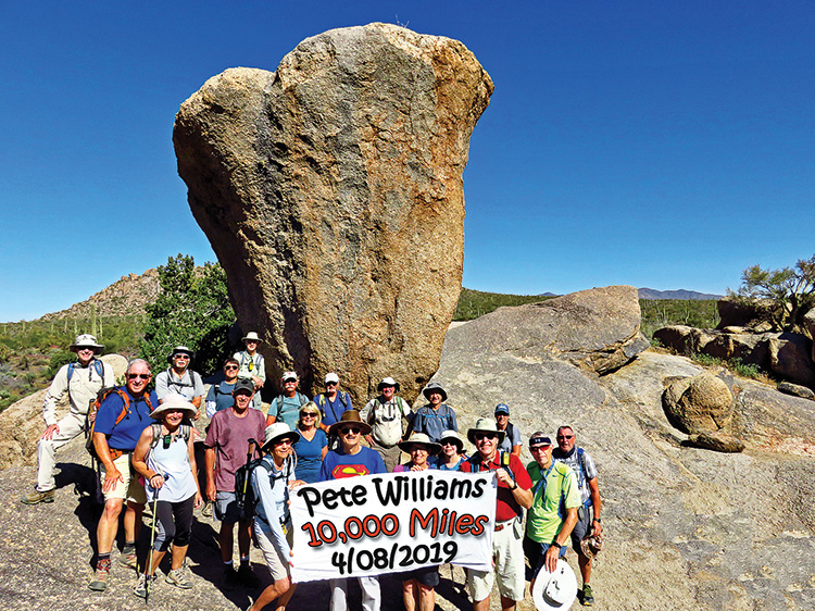 Pete Williams (Superman shirt) and 19 fellow hikers toast a unique accomplishment at Balanced Rock in the McDowell Sonoran Preserve; Photo by Lynn Warren.