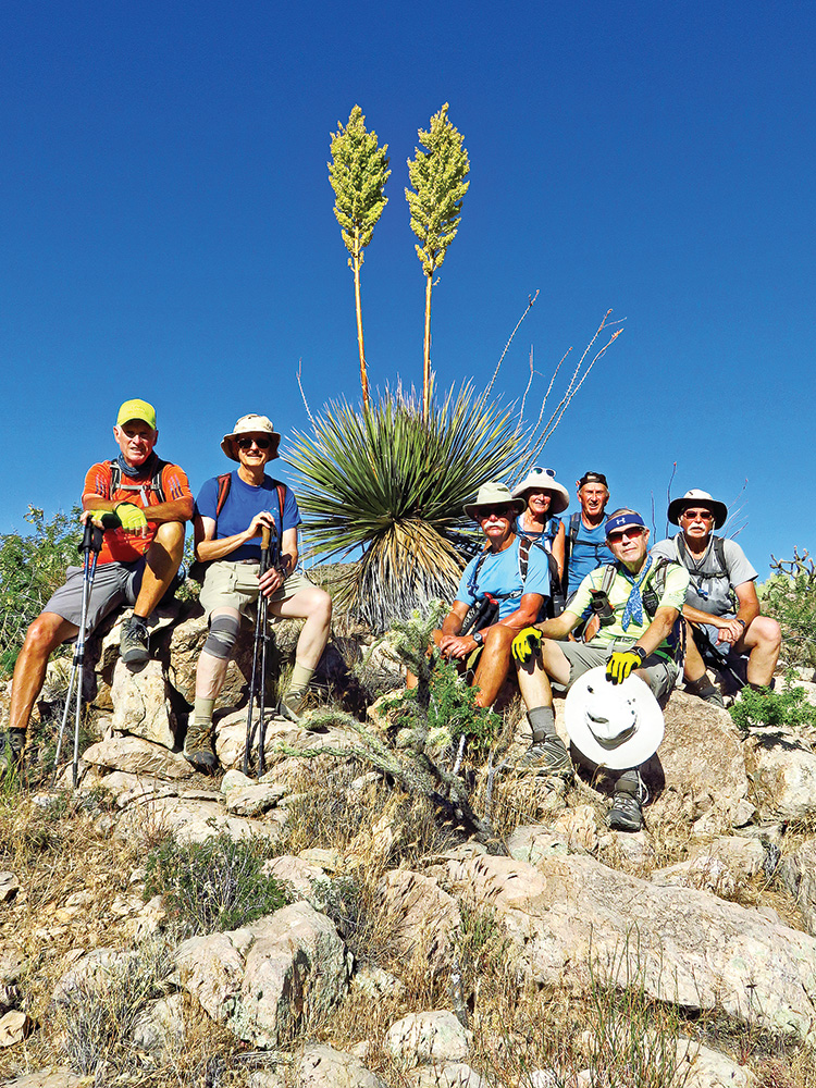 Ed Bobigian, Pete Williams, Dave “Ausy” Ausman, Eileen Lords-Mosse, Clare Bangs, Lynn Warren (photographer) and Wayne McKinney pausing for a photo op with an impressive blooming yucca.