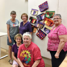 Some of the bags on display with Mary Hill, Maura Weddle, and Judy Frank (back); and Lynne Hupp and Cathy Howell (front). Thank you to all the faithful Community Sew Saturdays for making a difference in the lives of others.