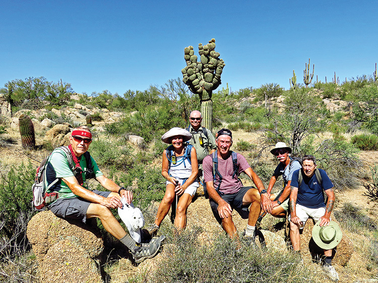 Left to right: Lynn Warren (photographer), Eileen Lords-Mosse, Neal Wring, Clare Bangs, Dave Ausman (Ausy), and Len Jeffery (London) posing with Michelin Man II along the Desperado Trail in the McDowell Sonoran Preserve.