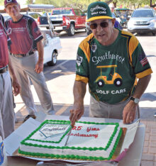 Bob Quarantino, one of the original players, is shown cutting the twenty-fifth-year anniversary cake.