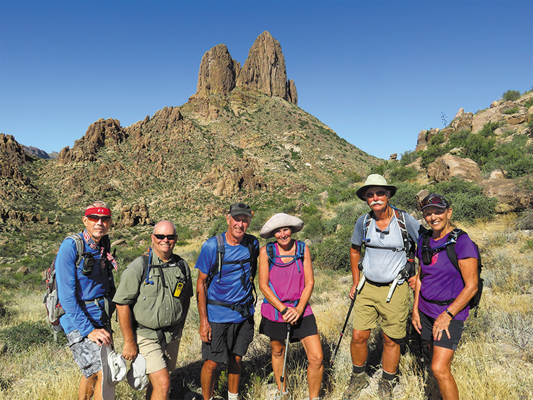 Left to right: Lynn Warren (photographer), Neal Wring, Clare Bangs, Eileen Lords-Mosse, Dave Ausman (“Ausy”), and Marilyn Reynolds on the Crosscut Trail with impressive Weaver’s Needle in the background.