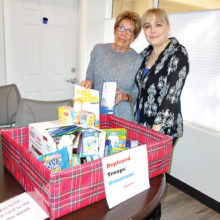 Marilyn Holland (left) drops off donations for Trudy’s care packages for our deployed troops. Photo by Priscilla Wardlow