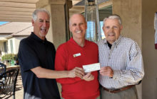 Ed Schneider (left) and Gary Jensen (right) hand donation to Don Belonax.