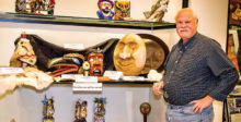David with several of his carvings on the middle shelf of the display window in the Creative Arts Center
