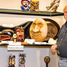 David with several of his carvings on the middle shelf of the display window in the Creative Arts Center