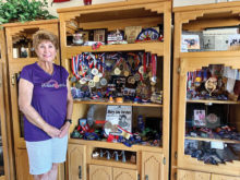 Mary Lou Furaus at home with her racquetball and pickleball trophies and medals