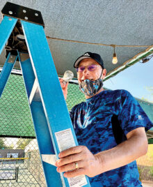 Steven Schaefer changing light bulbs at the pickleball courts.