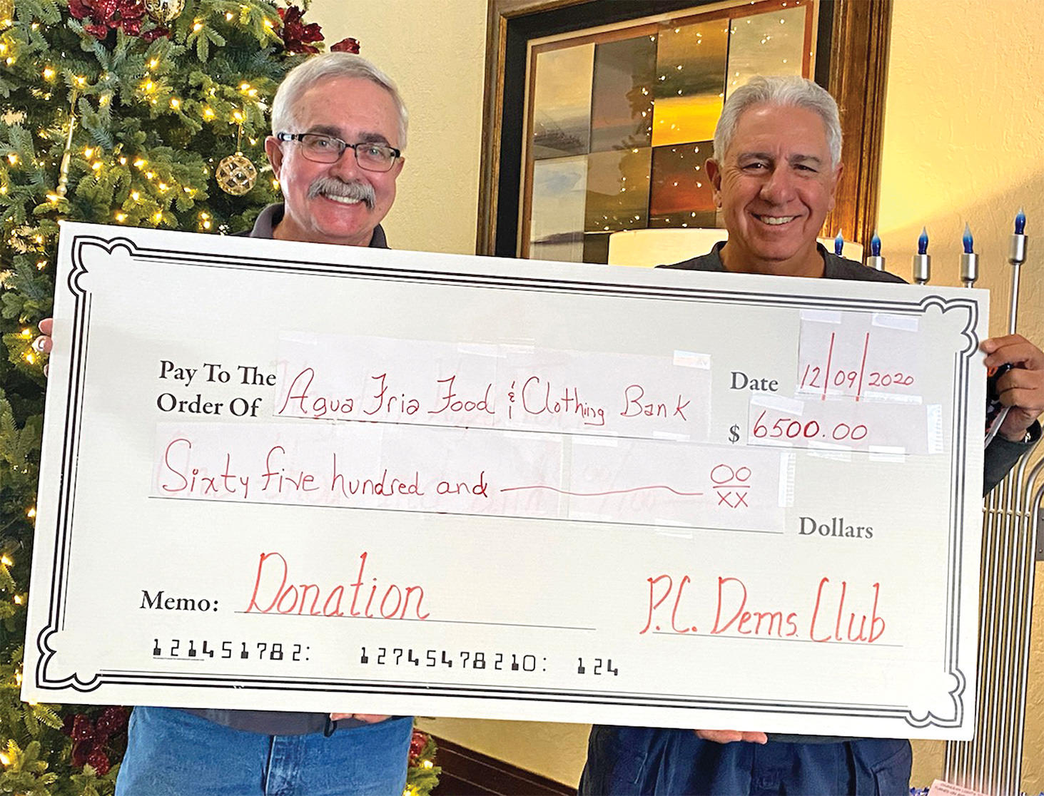 PC Dem Club President John Moore and Vice President Chuck Veltri display the mock check reflecting the club’s contribution to the Agua Fria Angel Tree project.