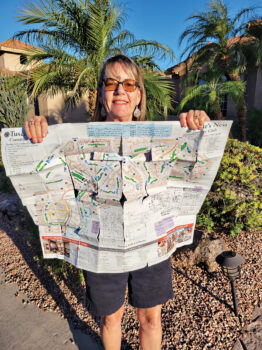 Susie Nee holding the PebbleCreek map after walking all 65 miles.